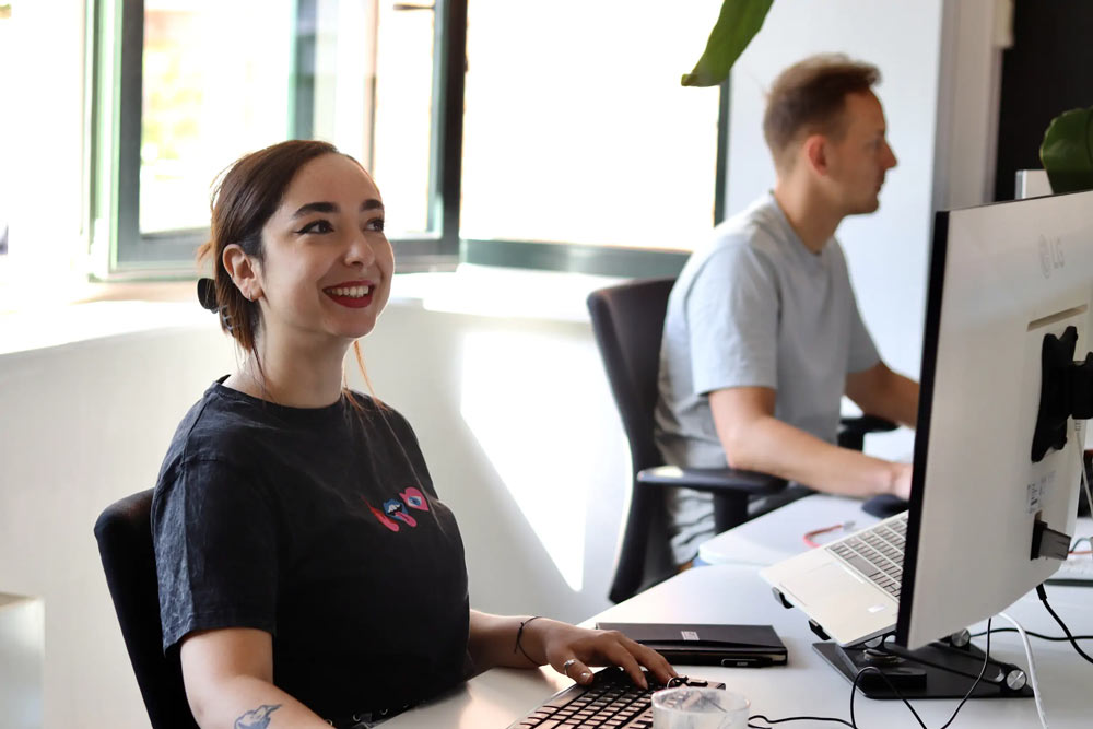 Collega Sibel lachend aan het bureau